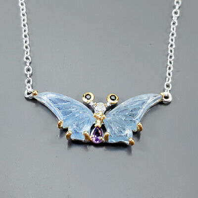 Χειροποίητο κολιέ σε ασήμι 925 με λευκό και κίτρινο επιχρύσωμα στα 14Κ με δύο σκαλιστές Ακουαμαρίνες σε κοπές hand carved fancy, στα 30.17 ct με transparent διαφάνεια καθαρότητα και έντονο γαλάζιο χρώμα. Στο κέντρο του κολιέ το μοτιφ αναπαριστά μια πανέμορφη πεταλούδα που τα φτερά της είναι δυο σκαλιστές ακουαμαρίνες και έχουμε στις κεραίες της δυο μπλε Ζαφείρια σε στρογγυλή κοπή και συνολικό βάρος 0.06 ct και Opaque διαφάνεια καθαρότητα, και στο σώμα της πεταλούδας υπάρχει ένας Αμέθυστος σε κοπή pear με vvs διαφάνεια και ένα Sky Blue Τοπάζι στρογγυλό με vvs  στα 0.20 ct  . Η προέλευση των λίθων είναι από την Βραζιλία και την Μοζαμβίκη.